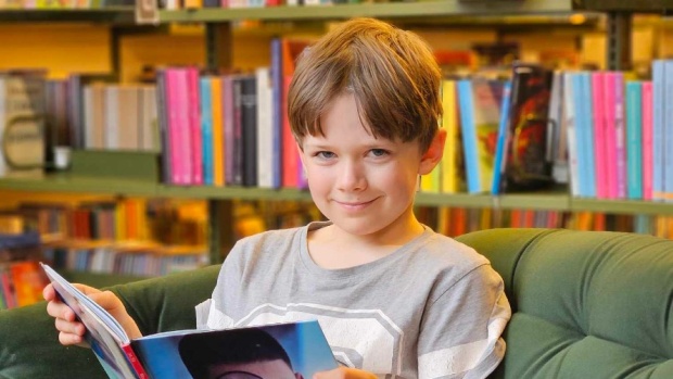 Samuel Lund kommer ofte på børnebiblioteket i Holstebro, hvor han nyder at slå sig ned i den grønne sofa med en stak bøger. (Foto: Holstebro Biblioteker)