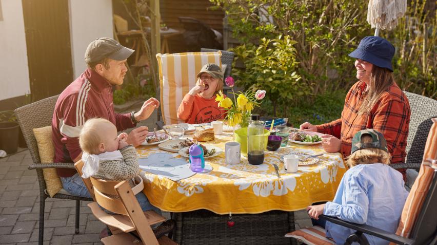 Familie spiser sammen i haven