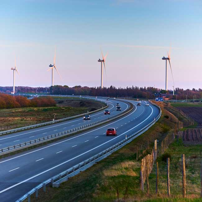 Motorvej med vindmøller i baggrunden