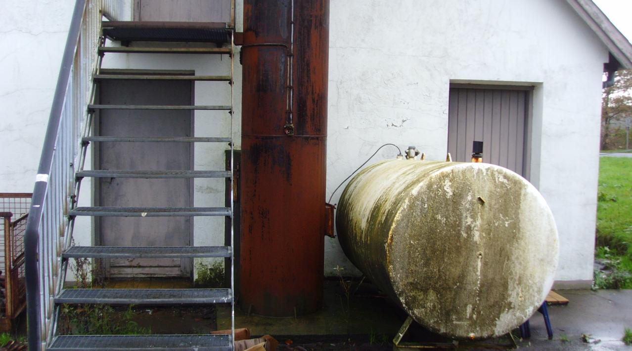 Billedet viser en olietank ved et stuehus